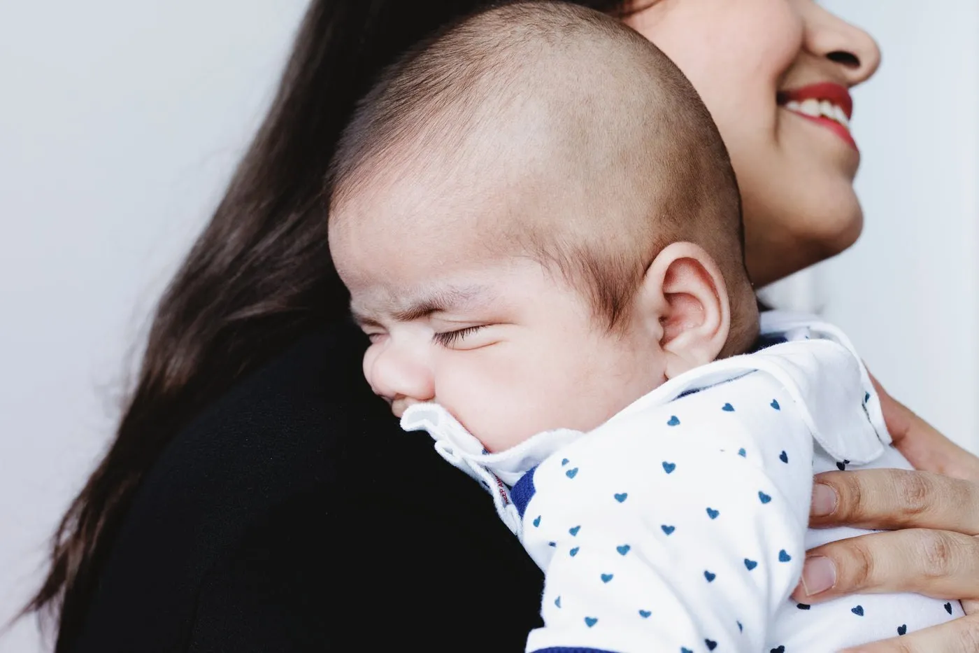 Un bébé endormi sur l’épaule de sa maman