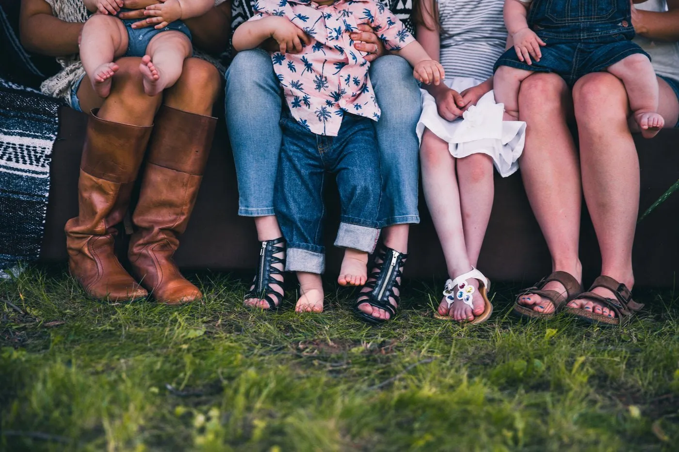 Une famille assise côte à côte dans l’herbe