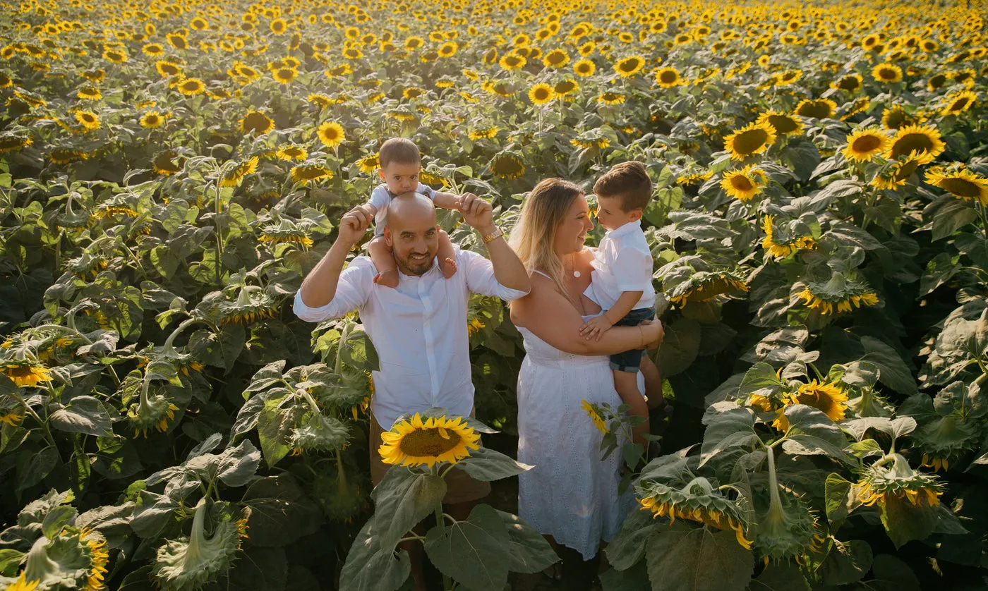 Une famille sourit dans un champ de tournesols