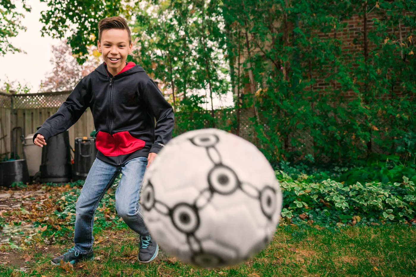 Un enfant joue au football en riant