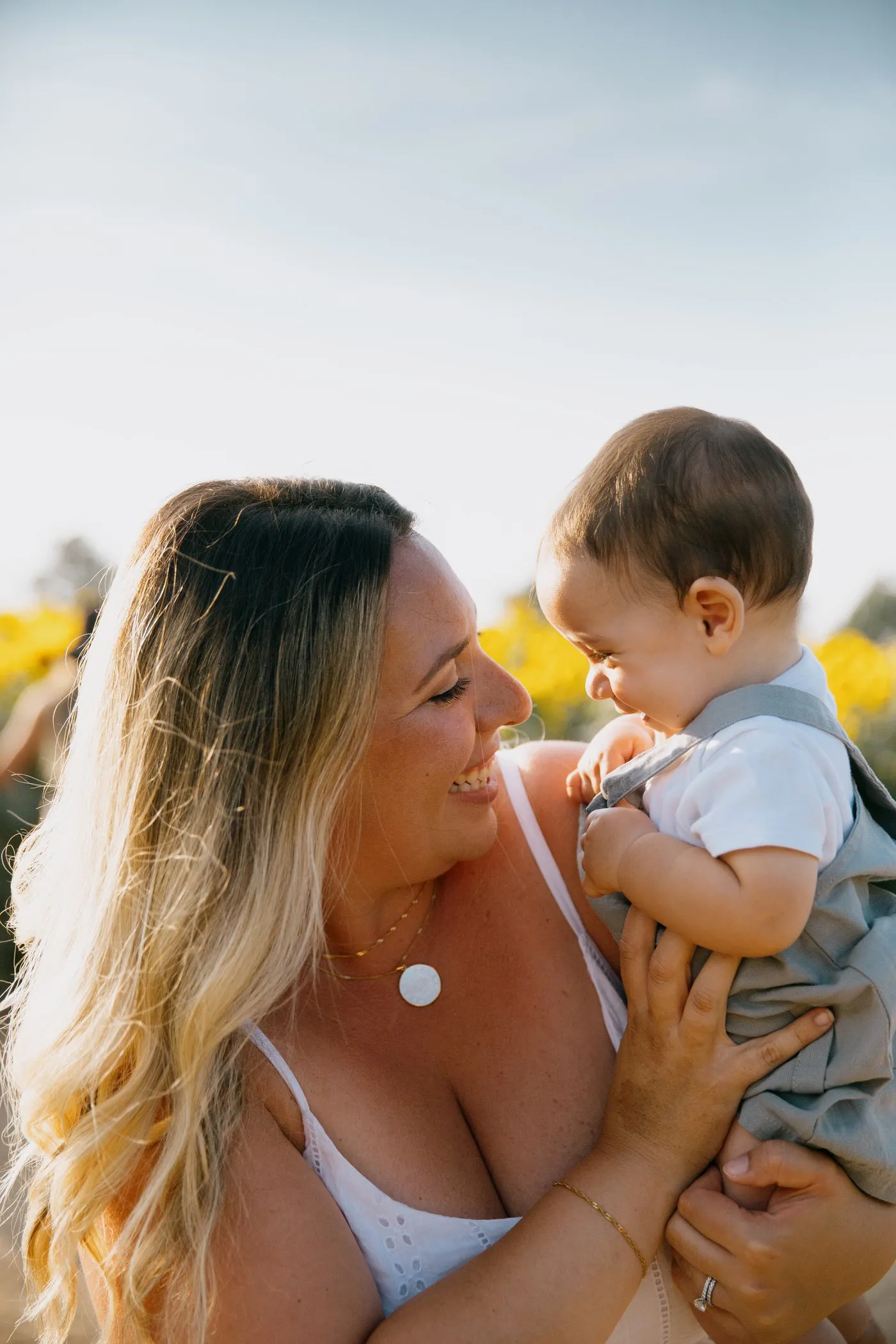 Une maman et son bébé rient ensemble dehors